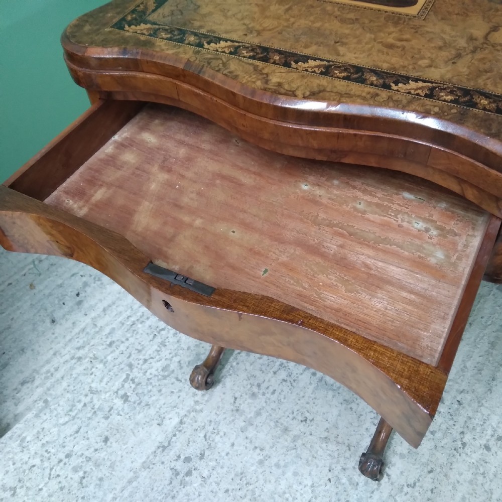 A Victorian burr walnut work table featuring a central Tunbridge ware marquetry landscape scene, serpentine edges, and turned legs with scroll feet. View IX