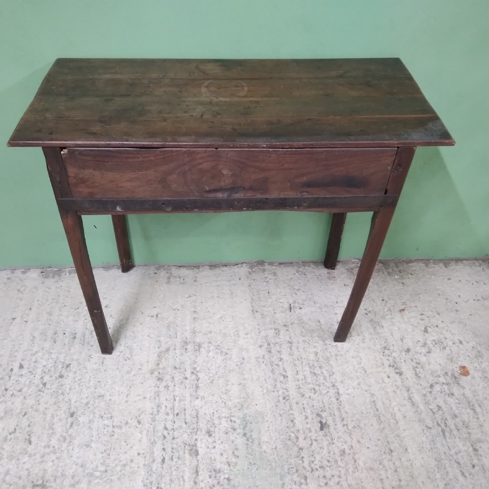 An antique fruitwood lowboy table featuring three drawers with brass drop handles, a shaped lower apron, and four square legs. View X