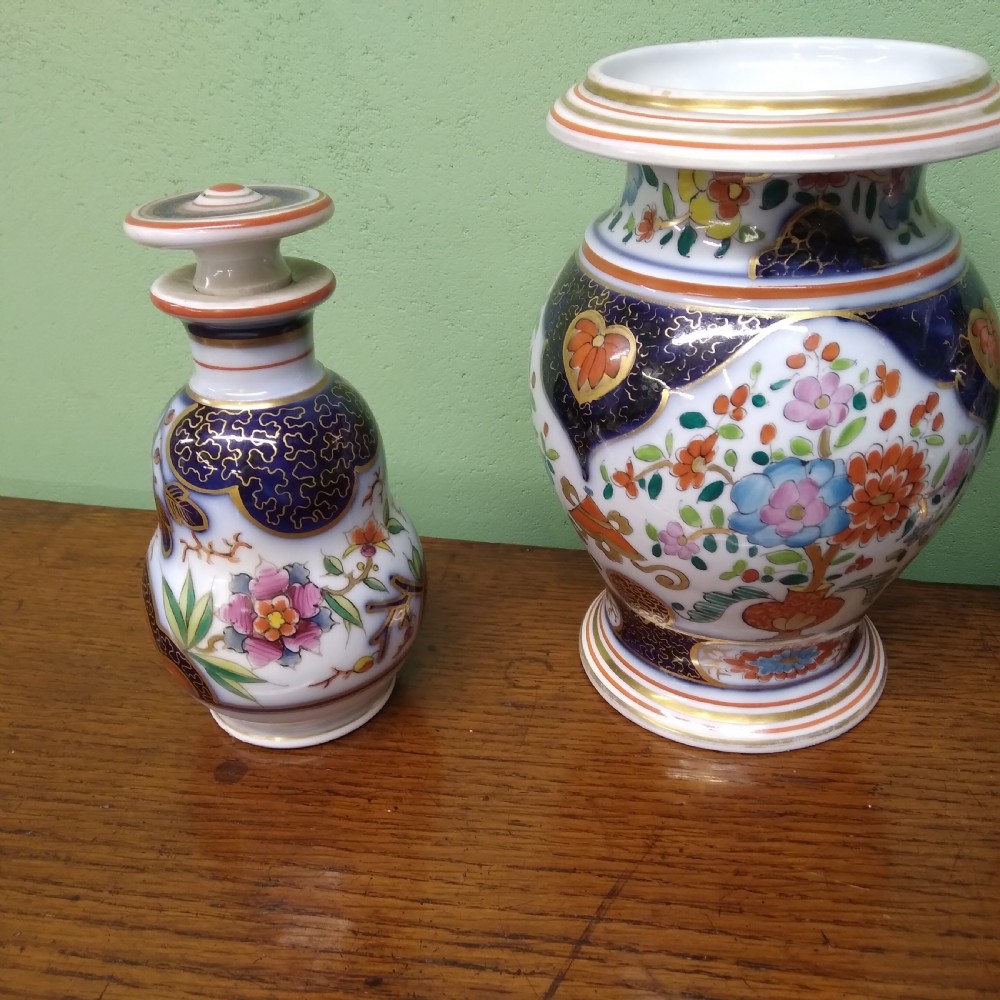 A four-piece antique Continental porcelain garniture set featuring two central urn-shaped vases and two outer stoppered bottles with cobalt blue panels and polychrome floral decoration. View II