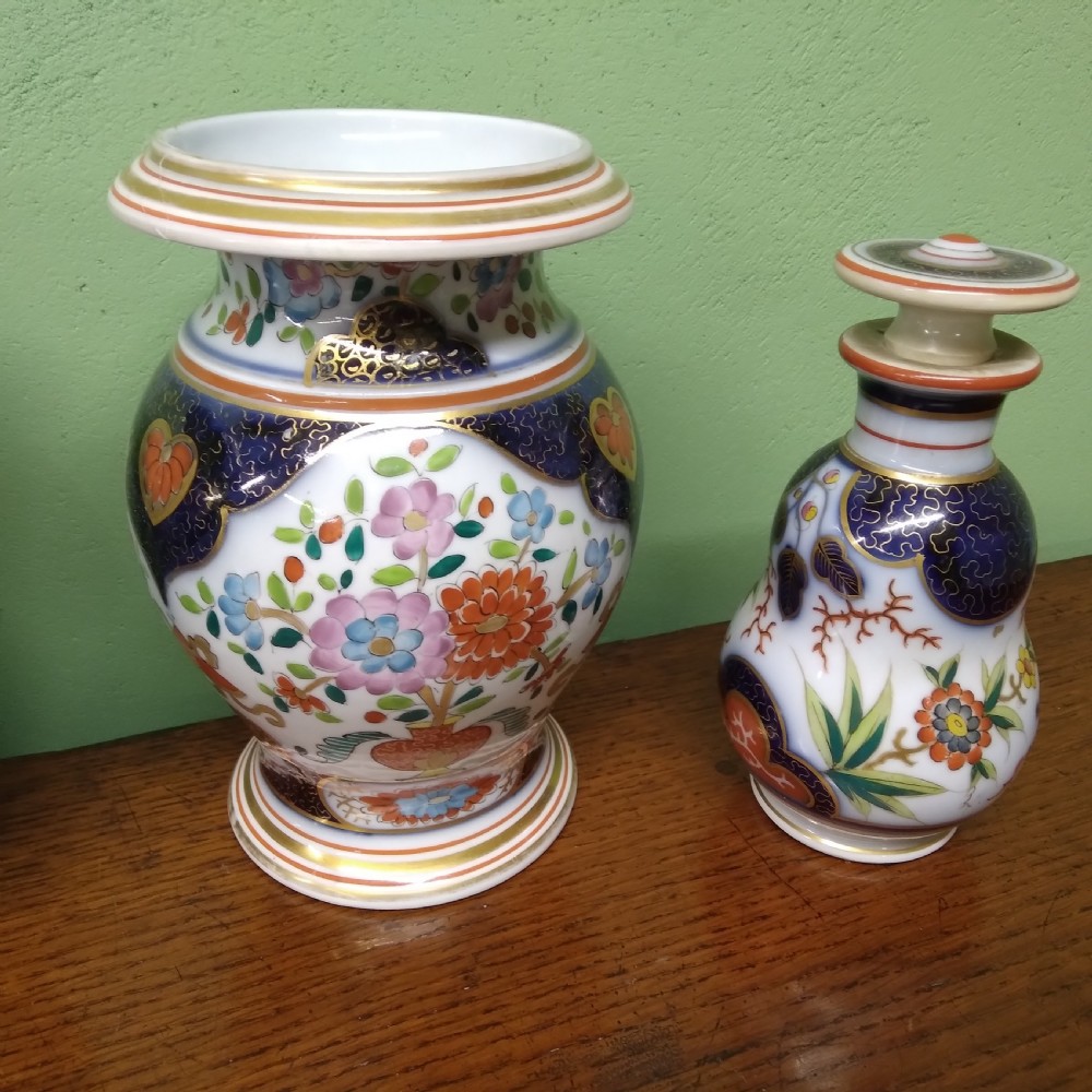 A four-piece antique Continental porcelain garniture set featuring two central urn-shaped vases and two outer stoppered bottles with cobalt blue panels and polychrome floral decoration. View III