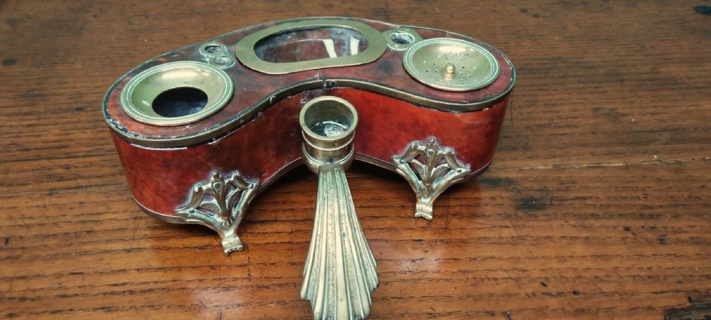 An 18th-century French kidney-shaped desk standish crafted from red tortoiseshell veneer with decorative gilt brass mounts and integrated wells. View III