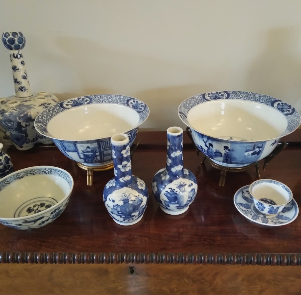 A collection of varied Chinese blue and white and polychrome porcelain vases, bowls, and jars displayed along a dark wood sideboard. View III