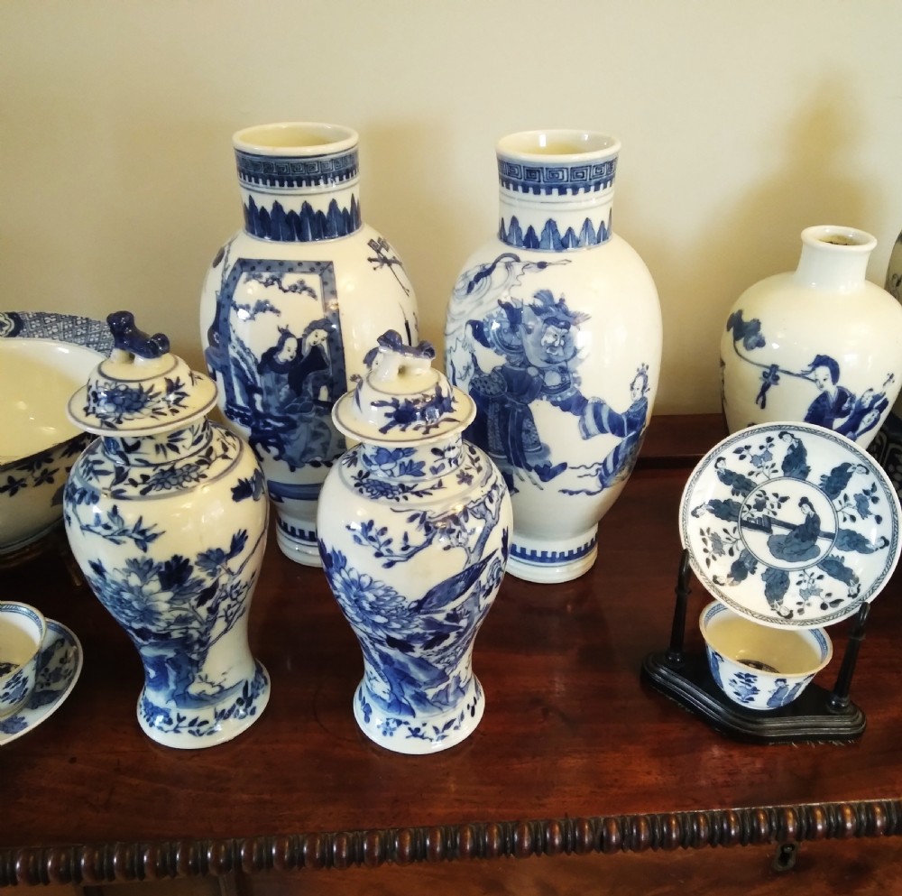 A collection of varied Chinese blue and white and polychrome porcelain vases, bowls, and jars displayed along a dark wood sideboard. View IV