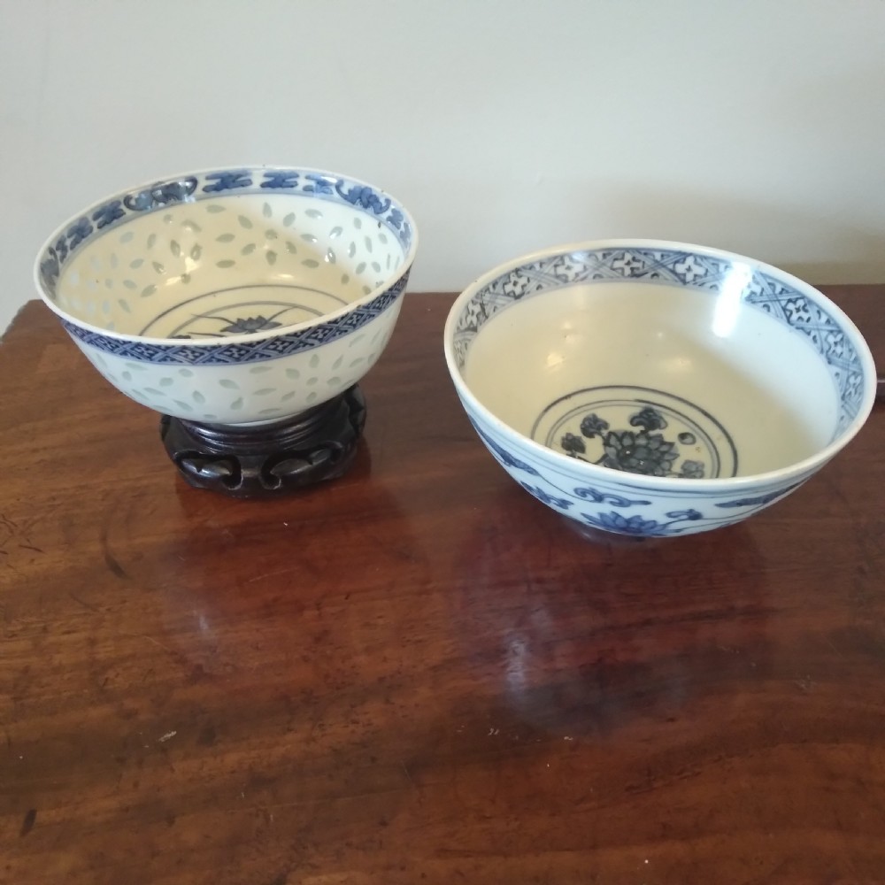 A collection of varied Chinese blue and white and polychrome porcelain vases, bowls, and jars displayed along a dark wood sideboard. View X