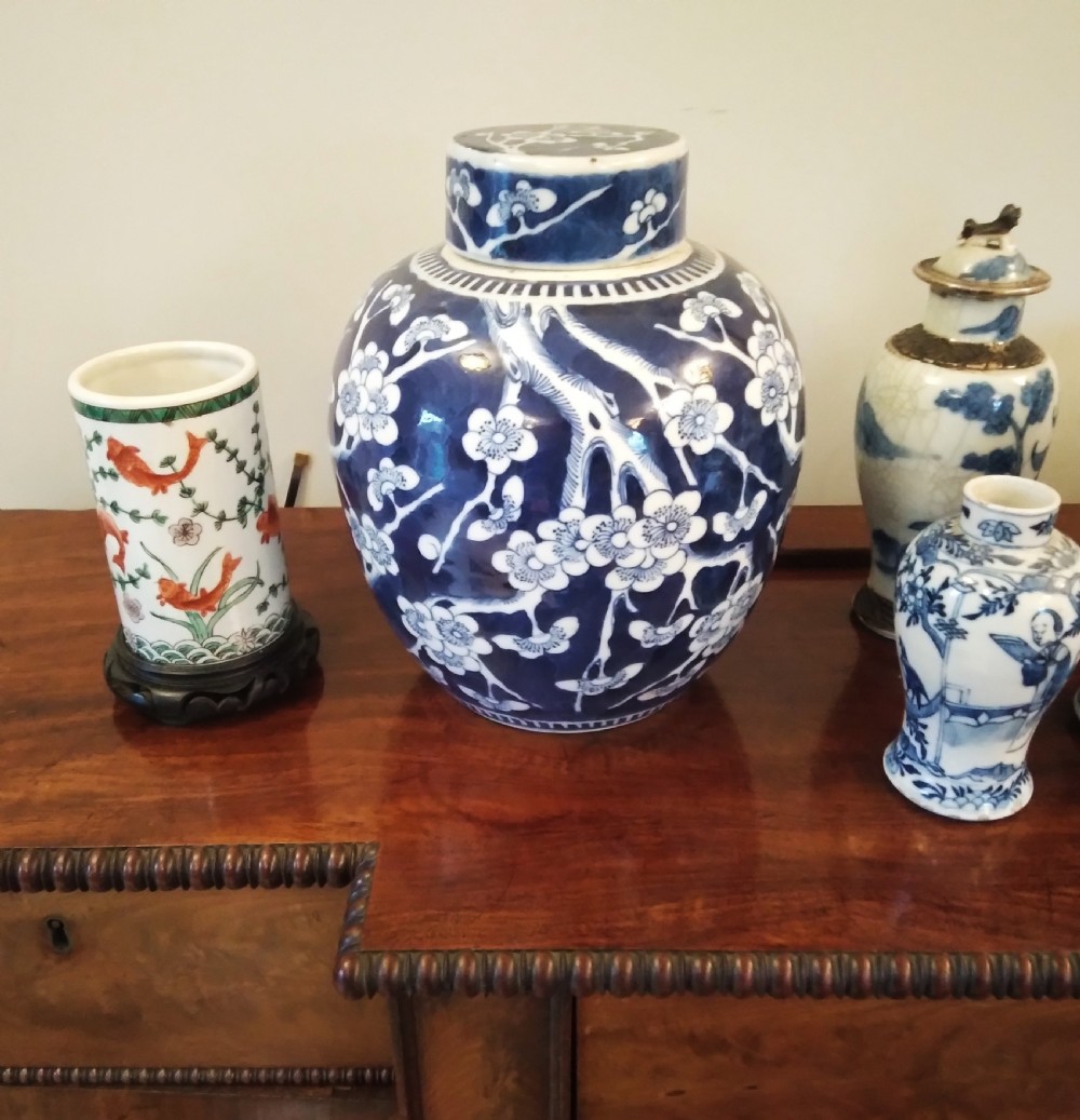 A collection of varied Chinese blue and white and polychrome porcelain vases, bowls, and jars displayed along a dark wood sideboard. View XXVI