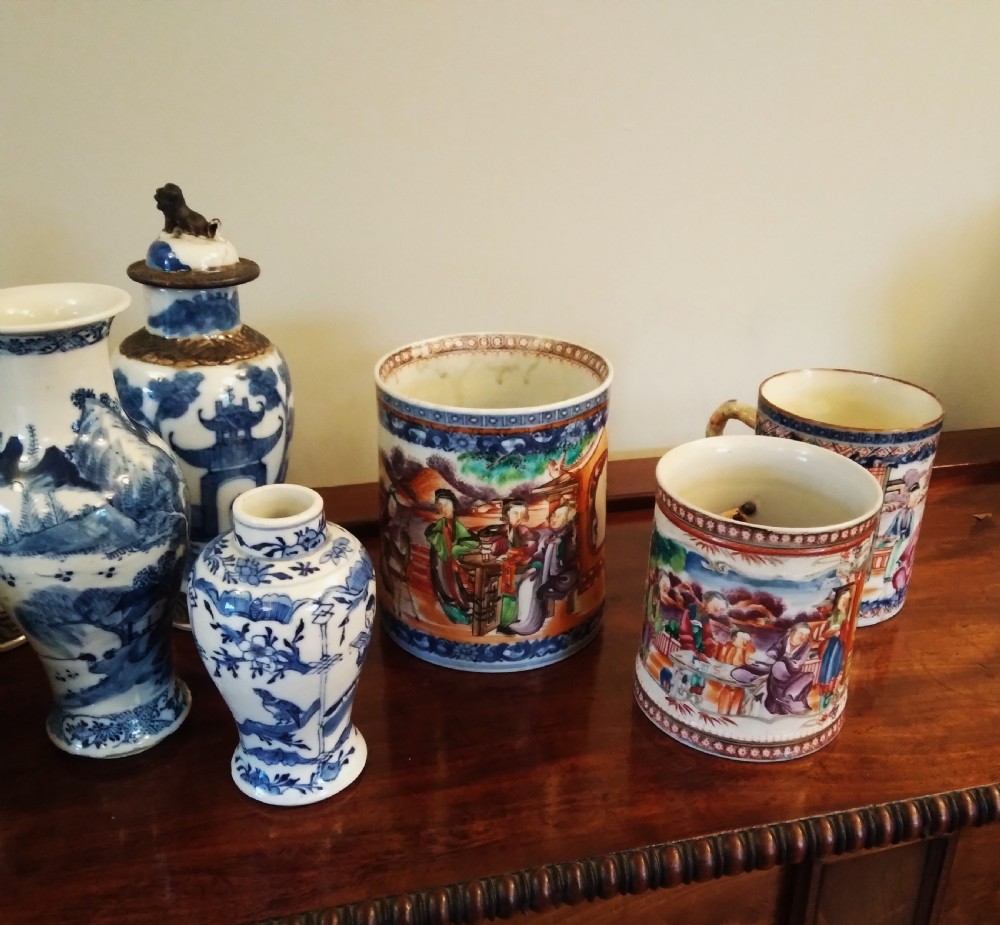 A collection of varied Chinese blue and white and polychrome porcelain vases, bowls, and jars displayed along a dark wood sideboard. View XXVII