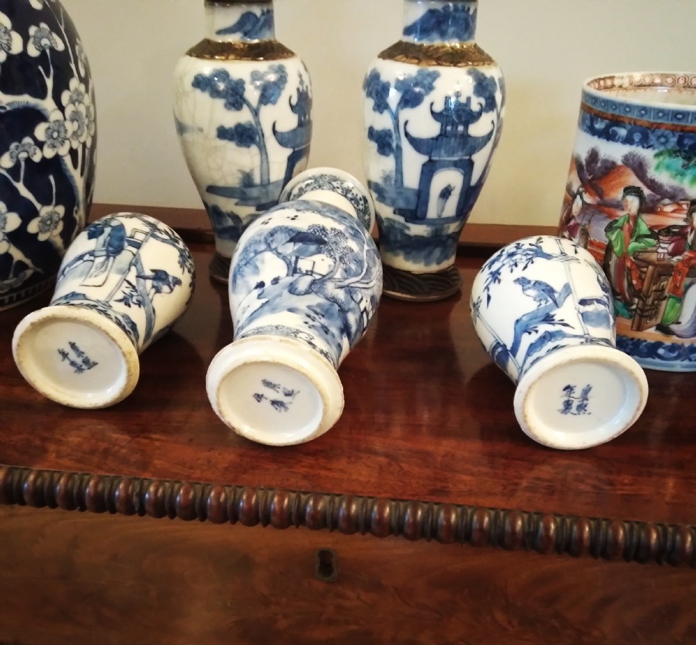 A collection of varied Chinese blue and white and polychrome porcelain vases, bowls, and jars displayed along a dark wood sideboard. View XXIX