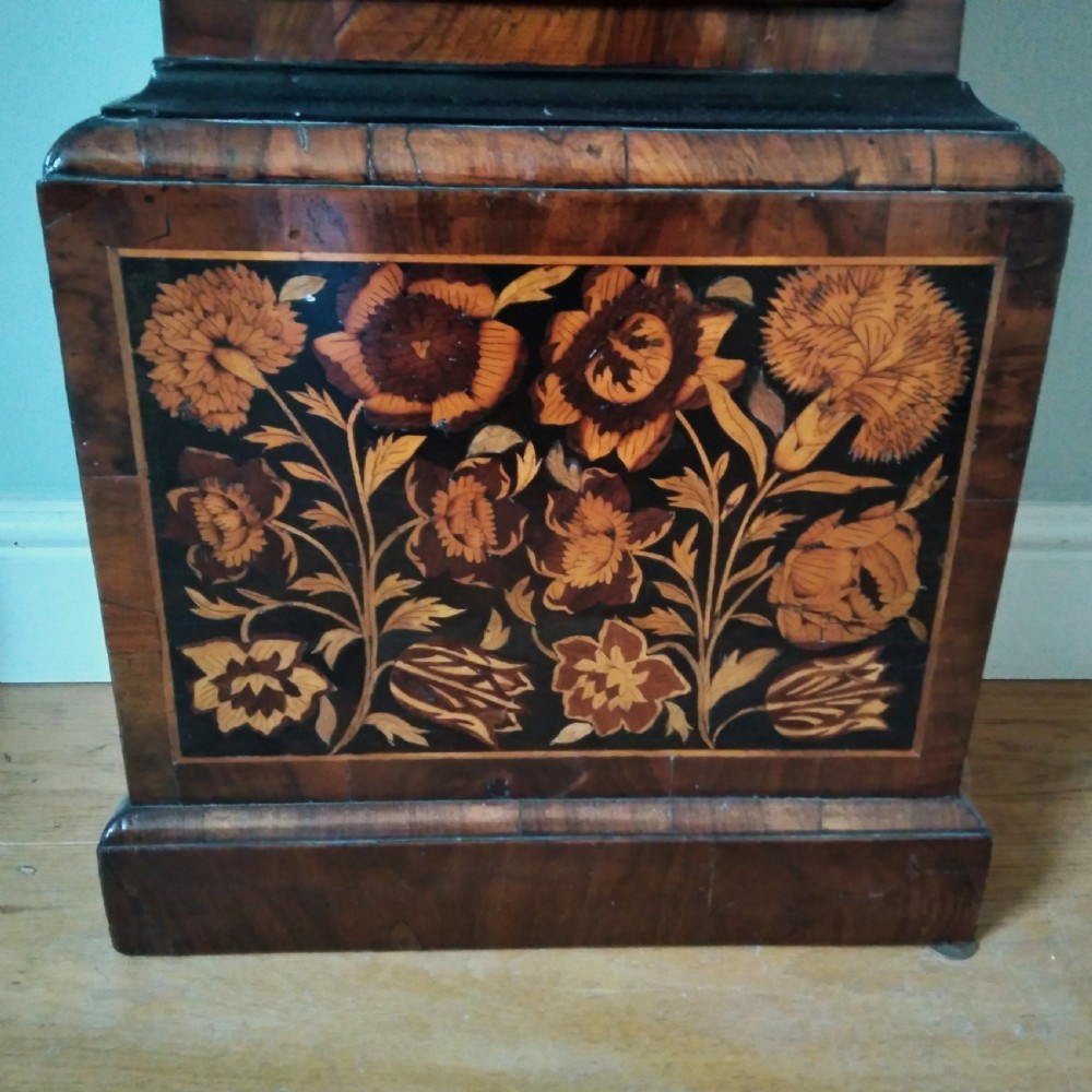 A 17th-century walnut longcase clock featuring floral marquetry inlays, a square brass dial, and twisted hood columns. View VIII