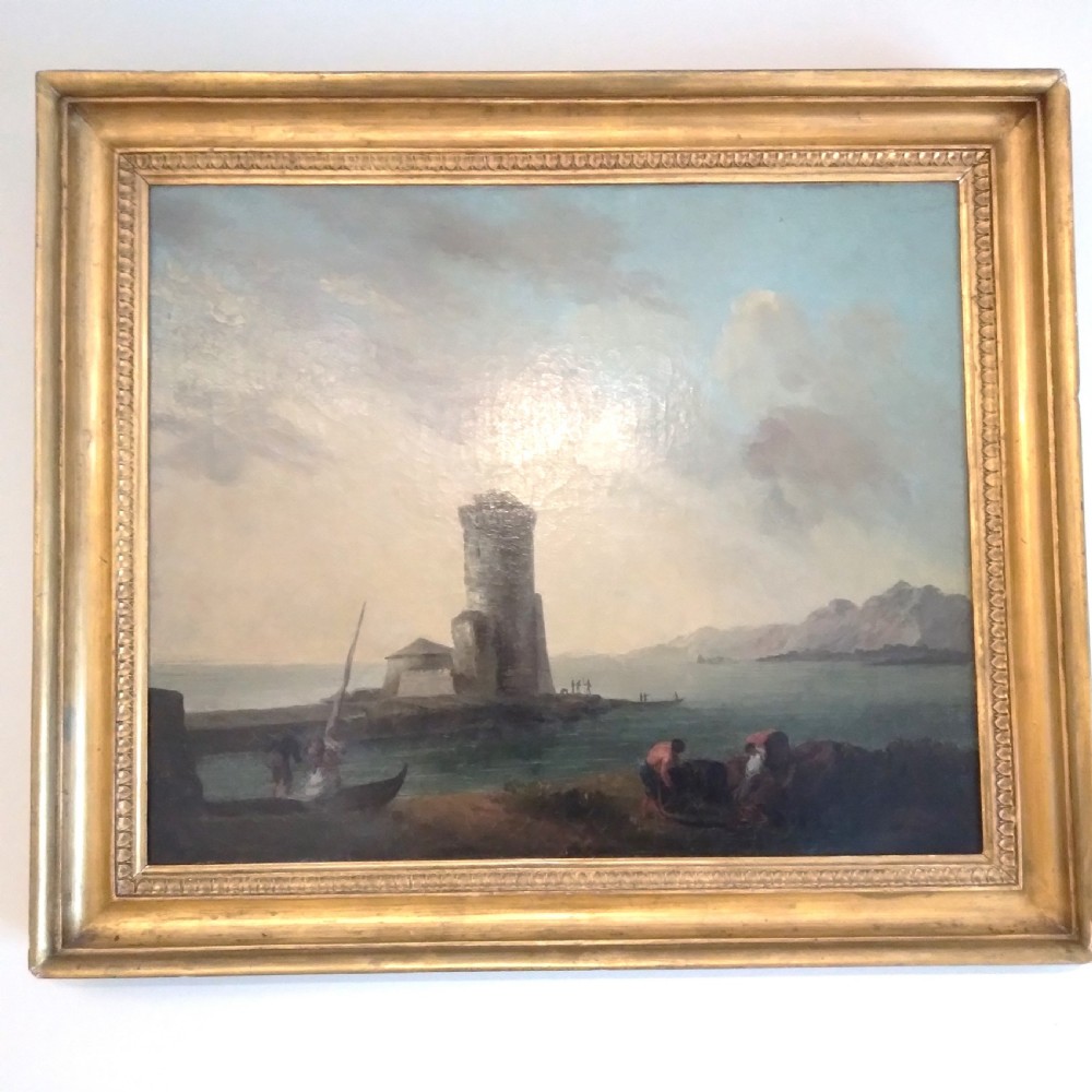 An 18th-century oil painting depicting a coastal seascape with a stone tower, figures, and small boats within a gilded wooden frame.