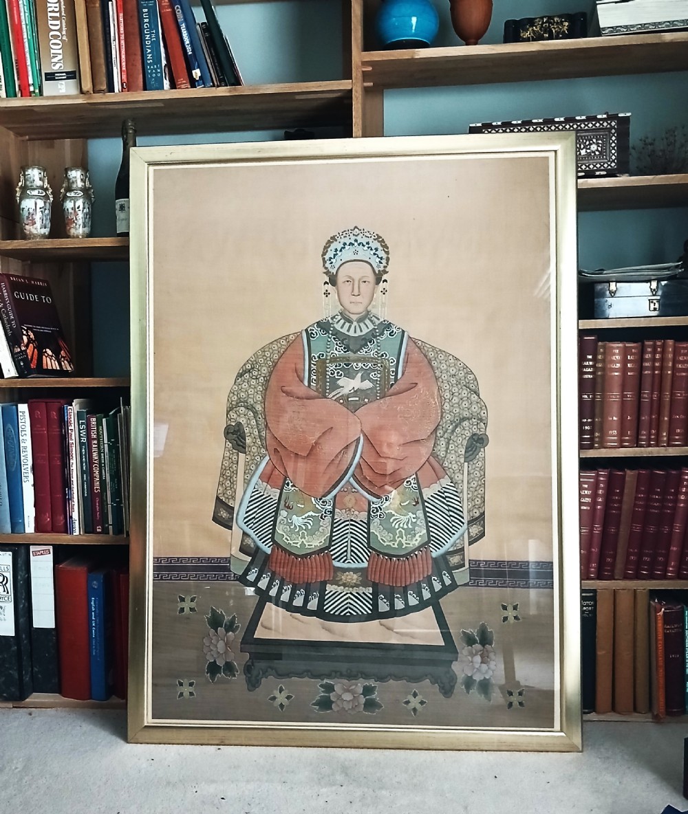 A framed Chinese ancestor portrait depicting a seated figure in a dark blue official court robe with a rank badge and court hat. View II