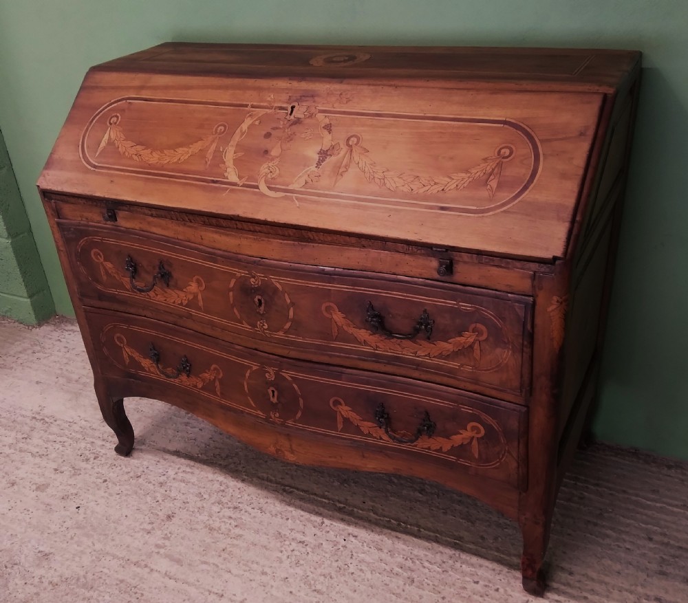 An 18th-century fruitwood writing bureau featuring a sloping fall-front lid with decorative marquetry garland inlays and two drawers below. View II
