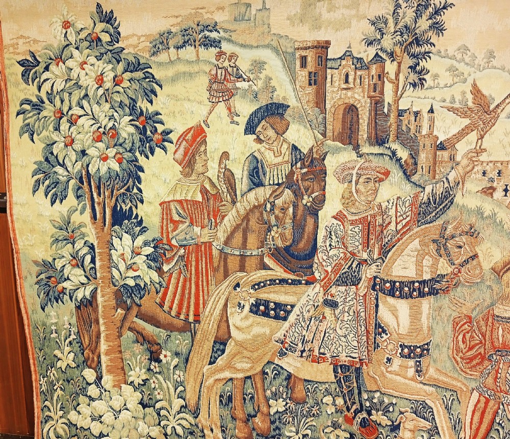A late 19th-century woven wall tapestry depicting a medieval hawking scene with figures on horseback, falcons, hunting dogs, and a distant castle backdrop. View II