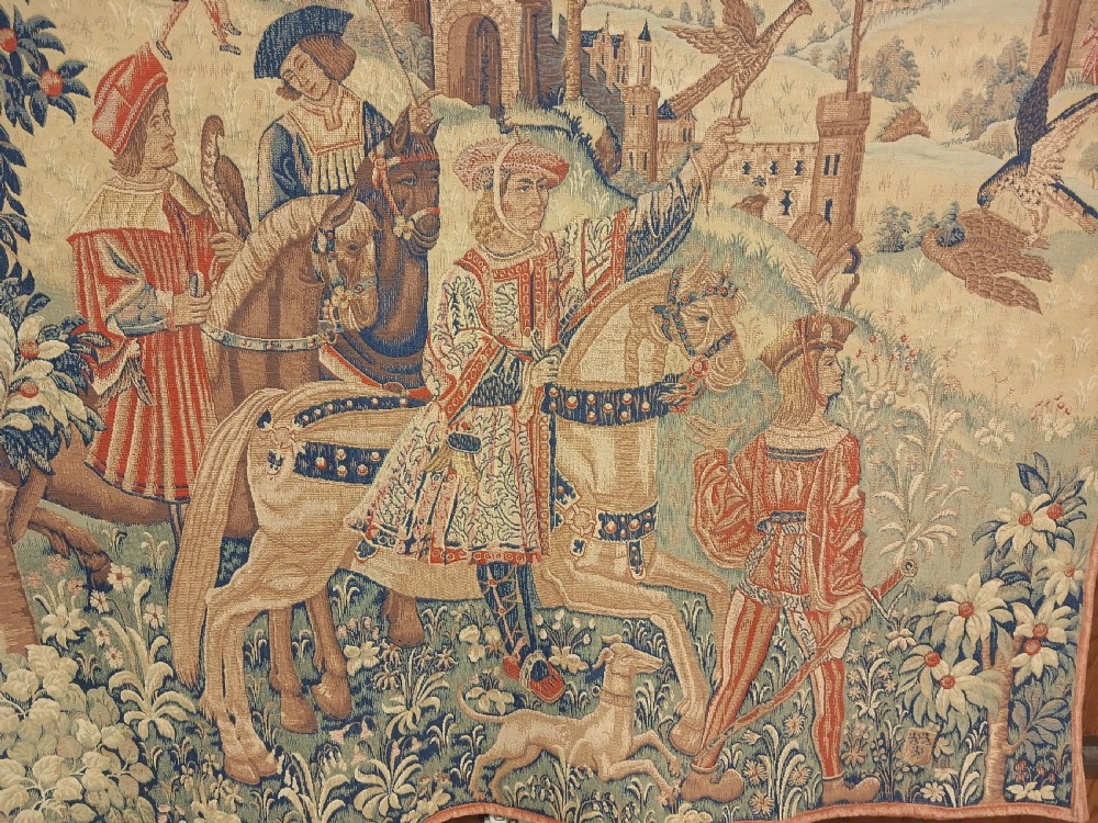 A late 19th-century woven wall tapestry depicting a medieval hawking scene with figures on horseback, falcons, hunting dogs, and a distant castle backdrop. View III