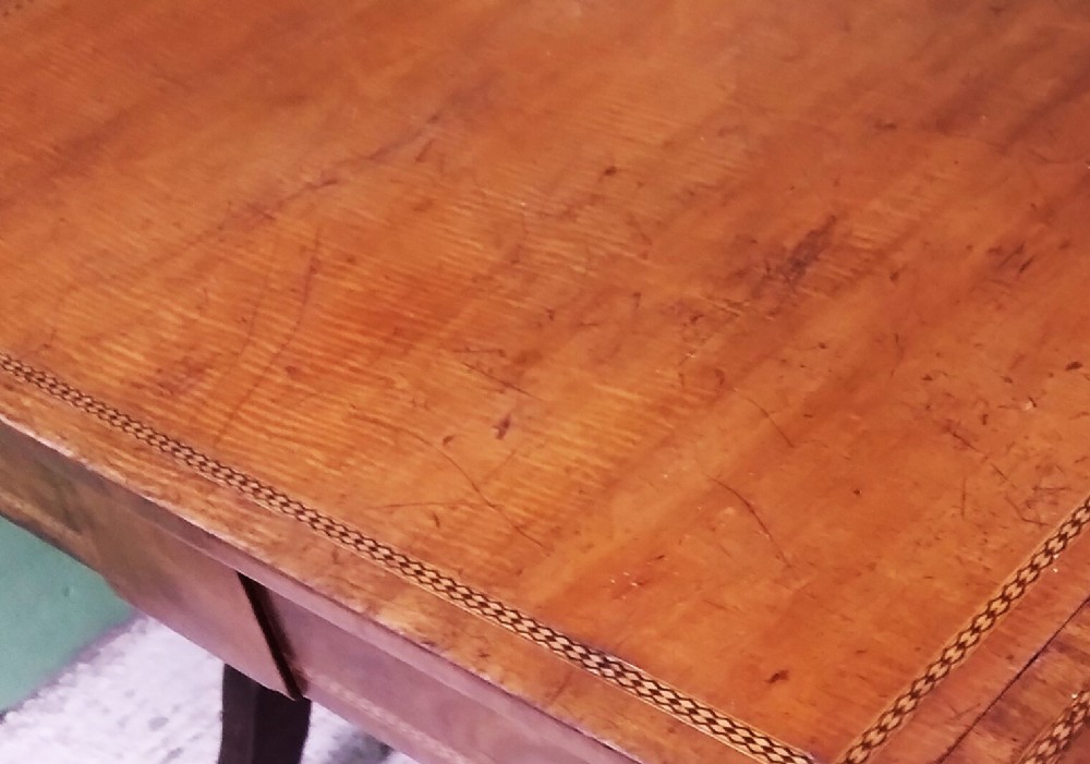 A George III mahogany drop-leaf sofa table featuring decorative border string inlay, two front drawers, a turned stretcher, and splayed legs fitted with brass castors. View III