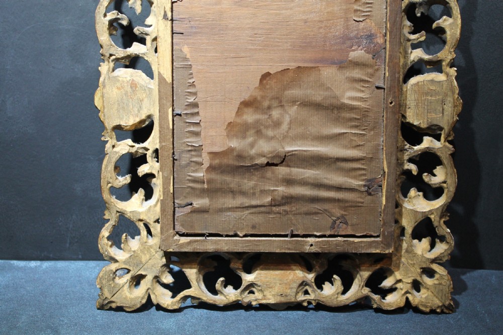 A 19th-century Florentine wall mirror featuring an ornate, pierced giltwood frame decorated with openwork scrollwork and shell carving. View VI
