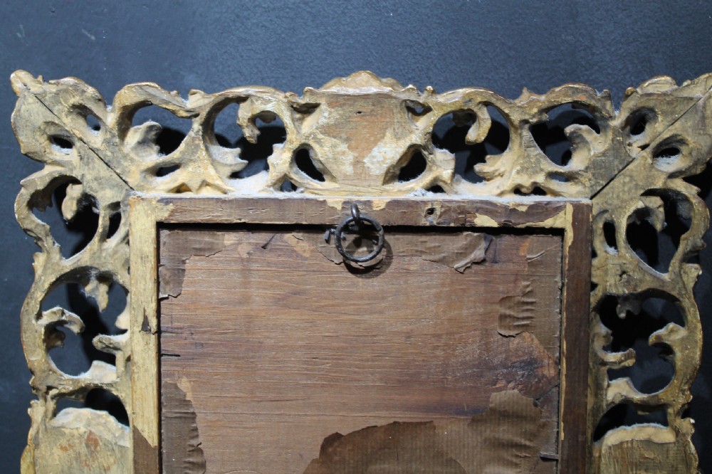 A 19th-century Florentine wall mirror featuring an ornate, pierced giltwood frame decorated with openwork scrollwork and shell carving. View VII