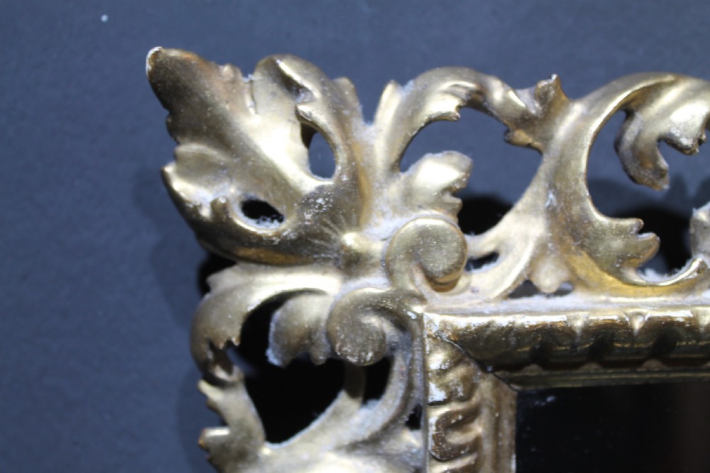 A 19th-century Florentine wall mirror featuring an ornate, pierced giltwood frame decorated with openwork scrollwork and shell carving. View X