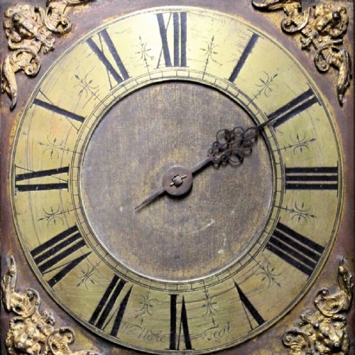 fig 3. A late 17th-century dark oak longcase clock hood featuring barley twist columns, carved frieze moulding, and a square brass dial.