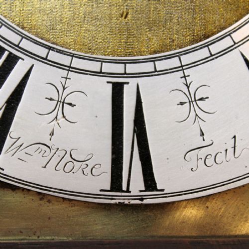 fig 4. A late 17th-century dark oak longcase clock hood featuring barley twist columns, carved frieze moulding, and a square brass dial.