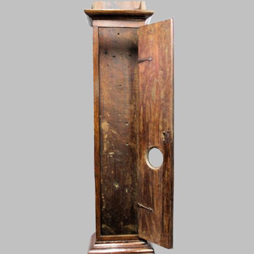 fig 5. A late 17th-century dark oak longcase clock hood featuring barley twist columns, carved frieze moulding, and a square brass dial.