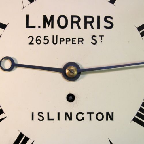 fig 2. A circular Victorian wall clock featuring a dark rosewood drum case, a polished brass bezel, and a cream painted dial signed L. Morris Islington with black Roman numerals.