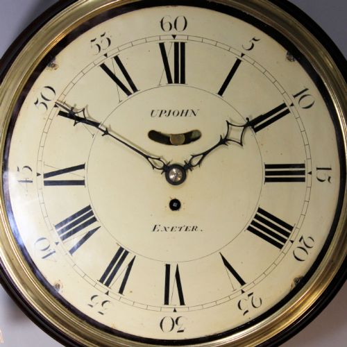 fig 1. A late 18th-century Georgian mahogany wall clock featuring a circular cream painted dial with Roman numerals, a brass bezel, and a salt-box wooden case.