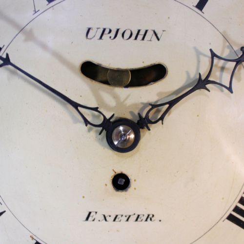 fig 2. A late 18th-century Georgian mahogany wall clock featuring a circular cream painted dial with Roman numerals, a brass bezel, and a salt-box wooden case.