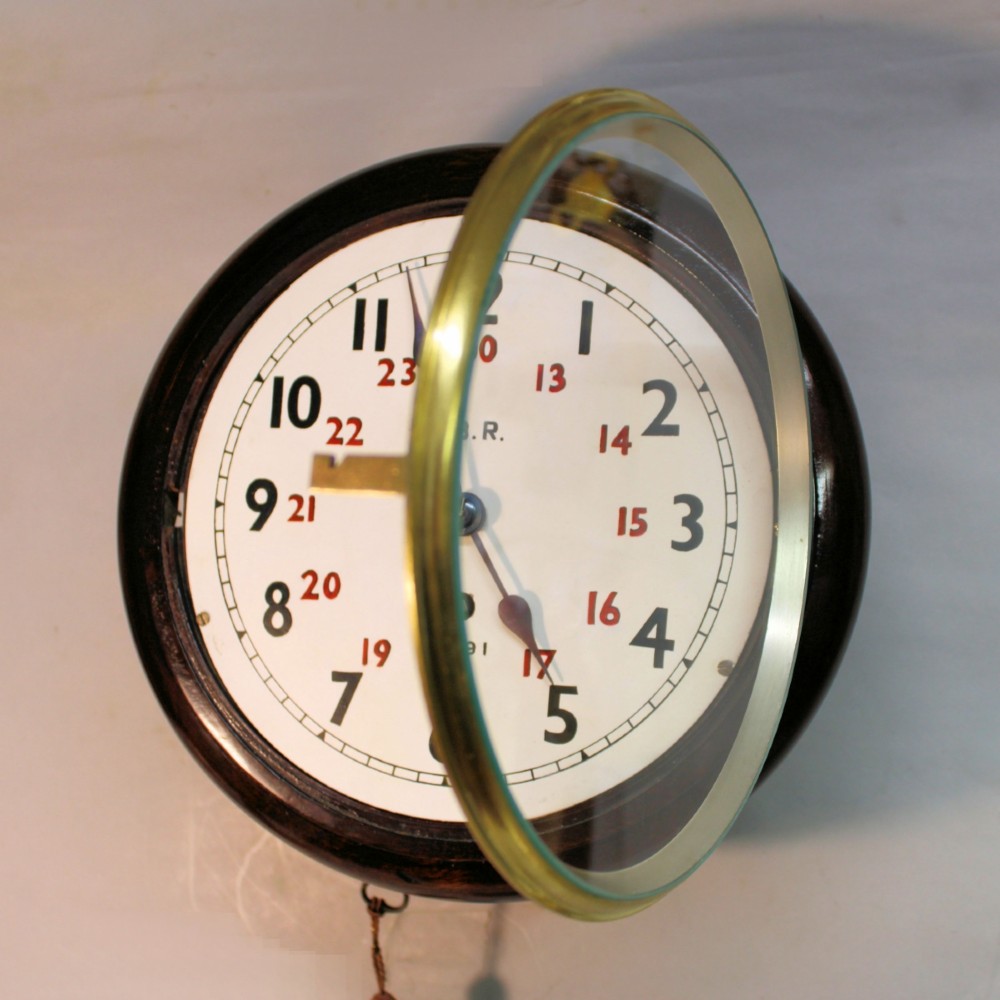 A round Victorian mahogany fusee wall clock featuring an eight-inch white dial with black and red numbers and a brass bezel. View VI