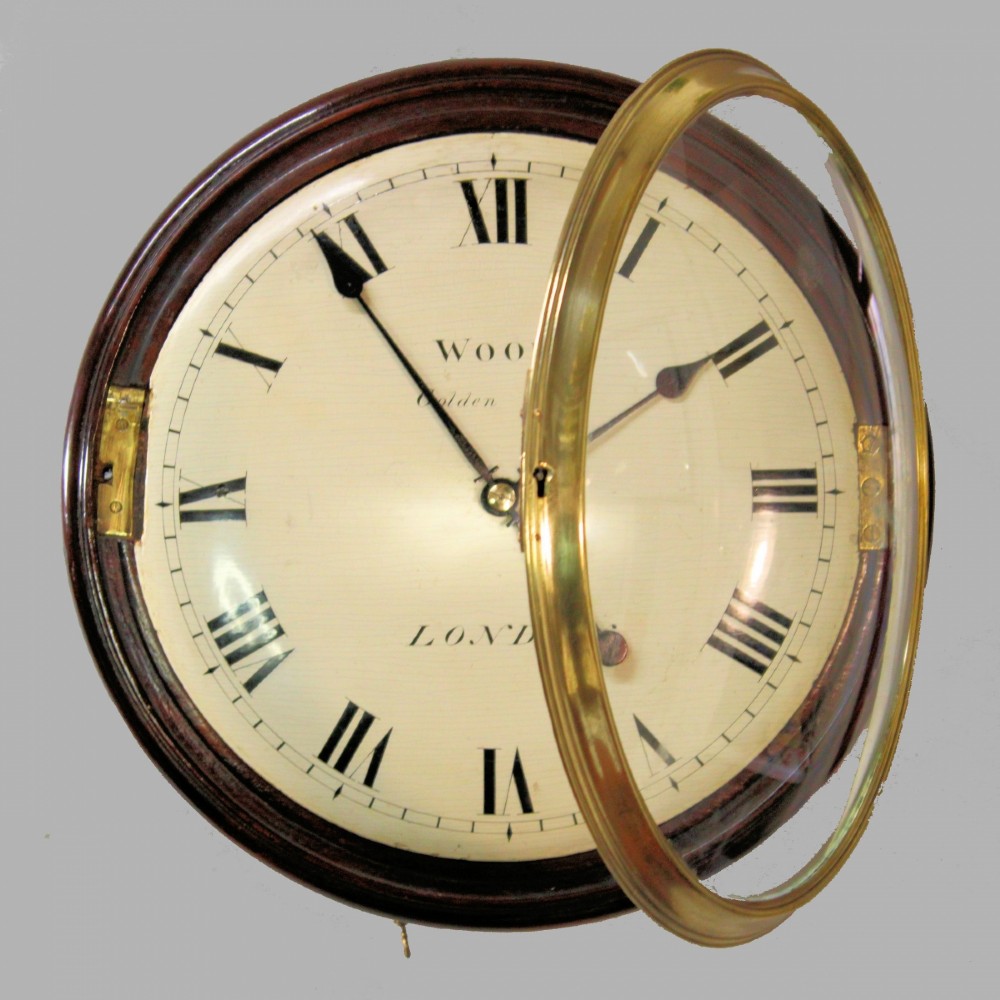 An antique Regency single fusee wall clock featuring an off-white convex wooden dial with Roman numerals, brass bezel, and a dark polished mahogany surround. View V