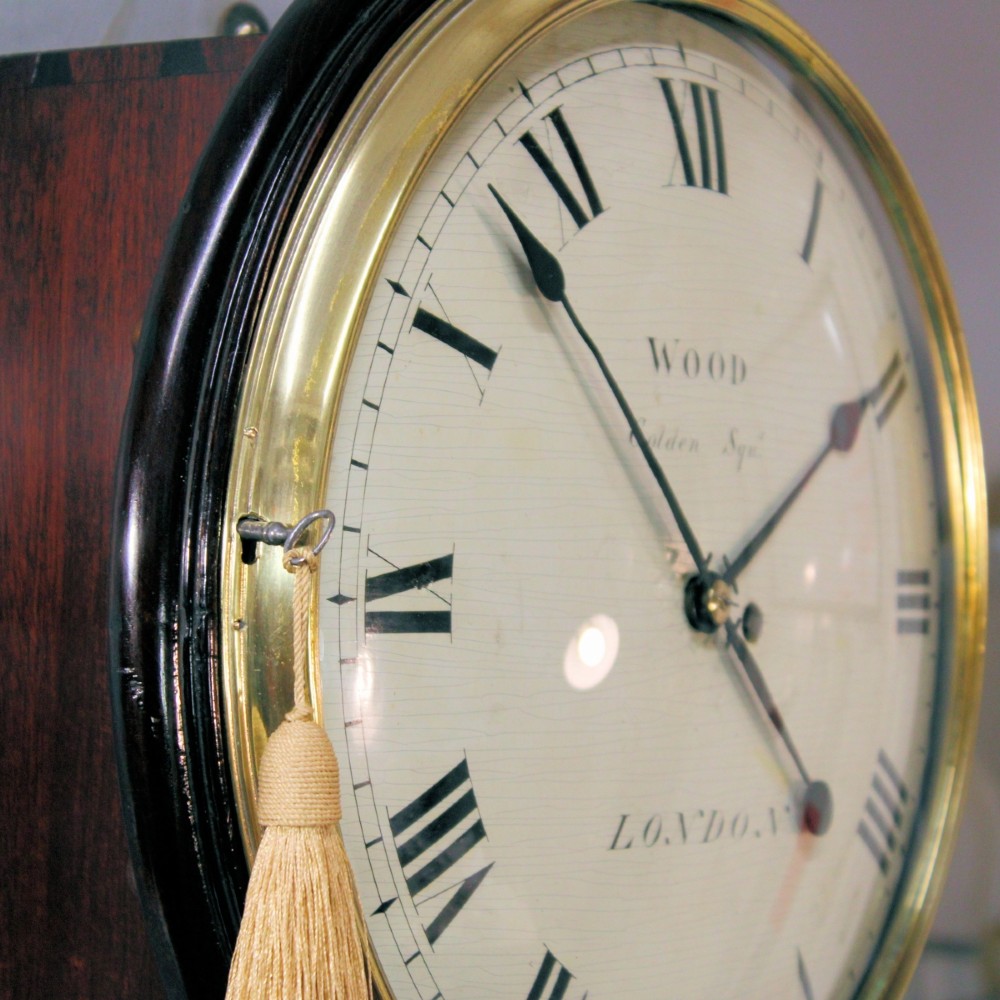 An antique Regency single fusee wall clock featuring an off-white convex wooden dial with Roman numerals, brass bezel, and a dark polished mahogany surround. View VI