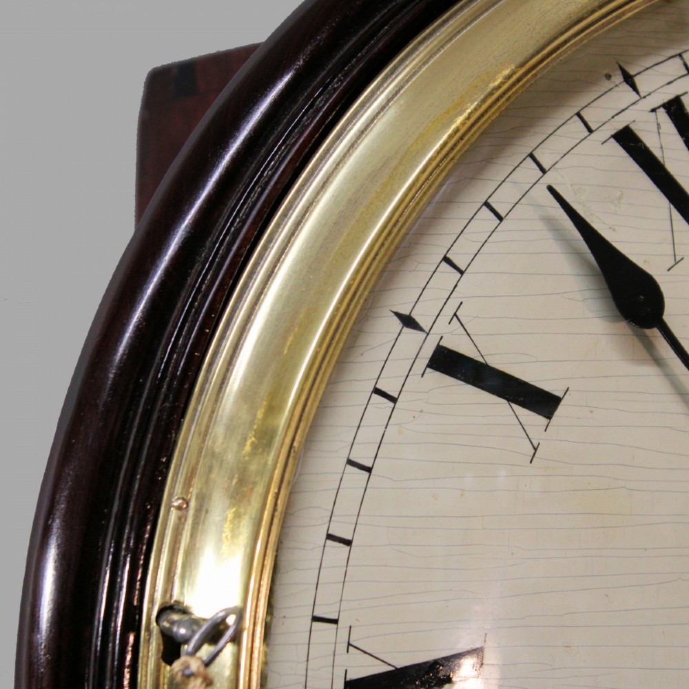 An antique Regency single fusee wall clock featuring an off-white convex wooden dial with Roman numerals, brass bezel, and a dark polished mahogany surround. View VII