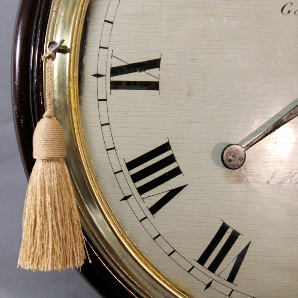 An antique Regency single fusee wall clock featuring an off-white convex wooden dial with Roman numerals, brass bezel, and a dark polished mahogany surround. View IX