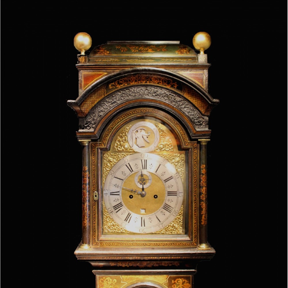 A tall early 18th-century dark green longcase clock decorated with gold Chinoiserie lacquer patterns and an arched brass dial. View V