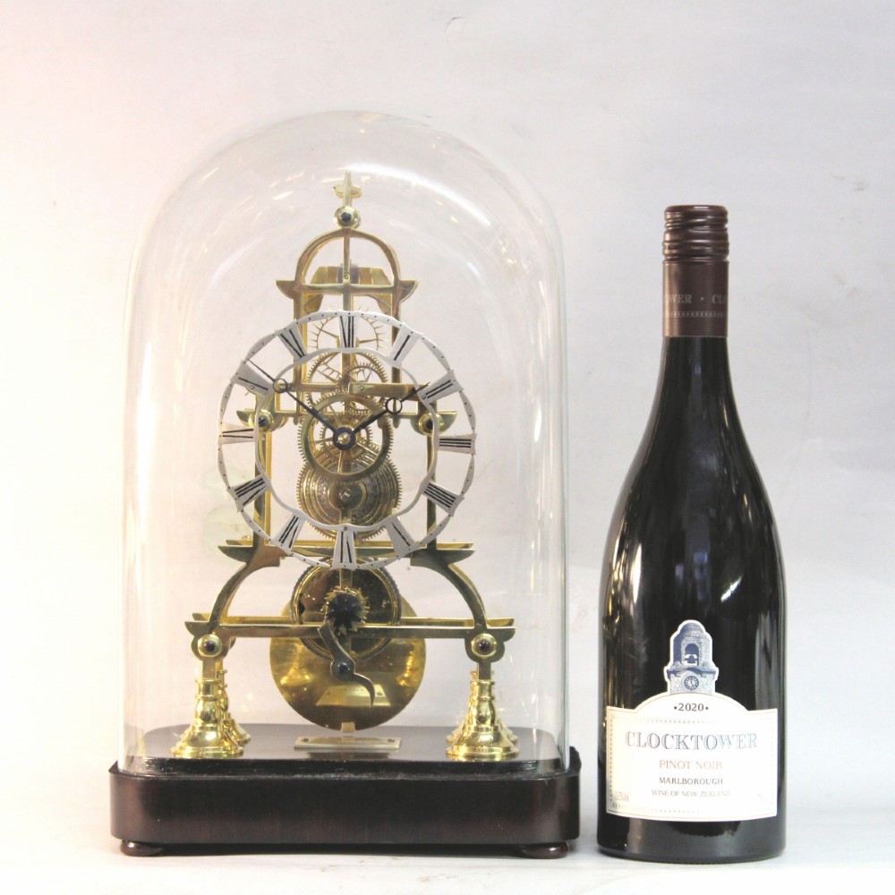 A Victorian brass skeleton clock featuring exposed internal gears, a silvered chapter ring, and a glass dome on a dark wooden base. View II