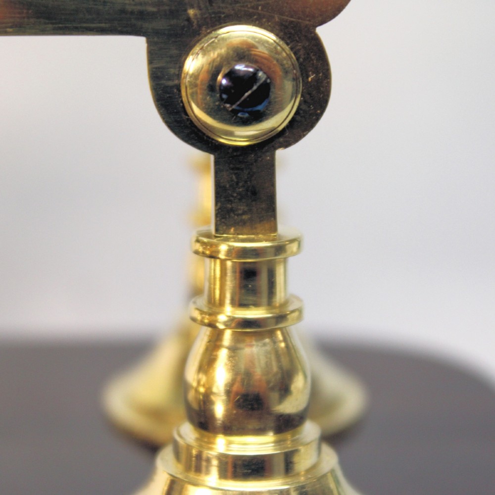 A Victorian brass skeleton clock featuring exposed internal gears, a silvered chapter ring, and a glass dome on a dark wooden base. View XI