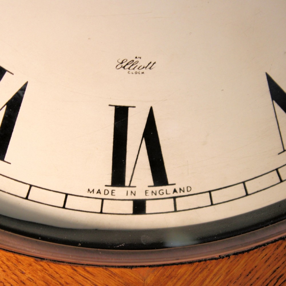 A circular twentieth-century oak wall dial clock with black Roman numerals on a cream face, inscribed Fattorini Bradford. View III