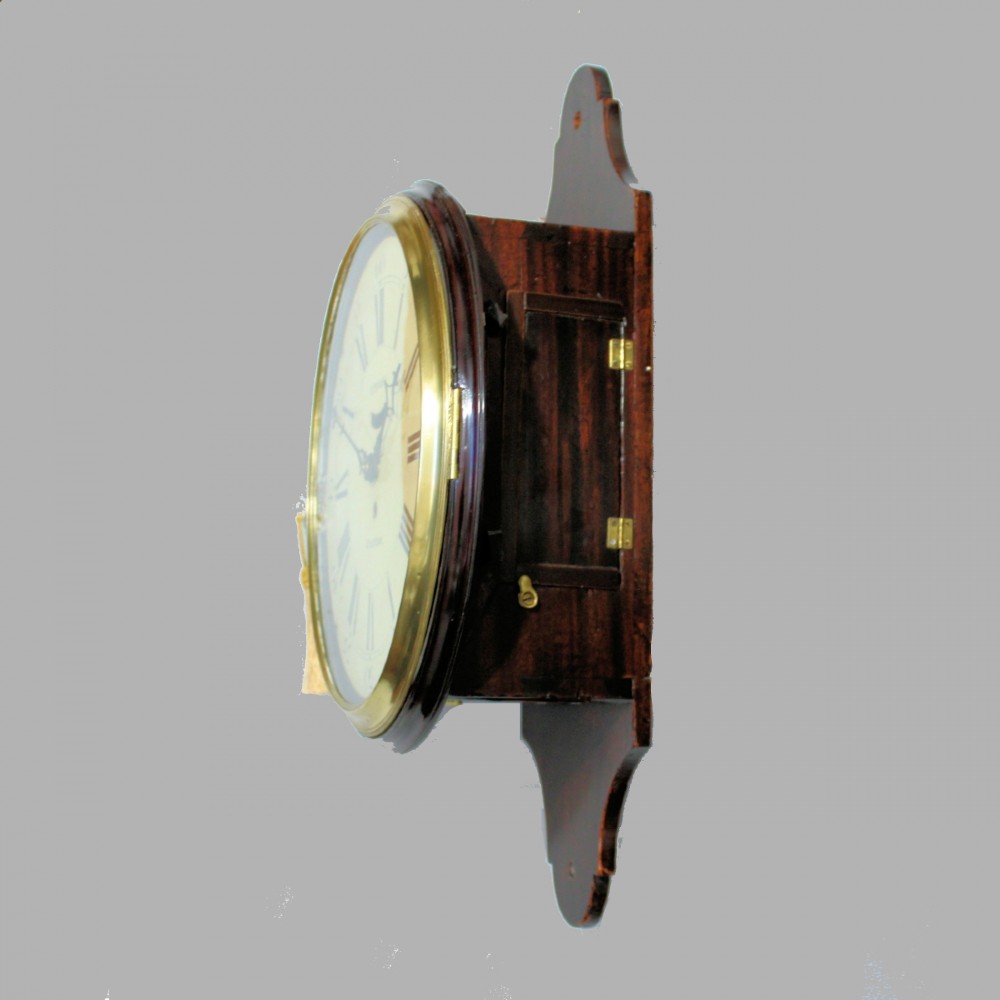 A late 18th-century Georgian mahogany wall clock featuring a circular cream painted dial with Roman numerals, a brass bezel, and a salt-box wooden case. View V