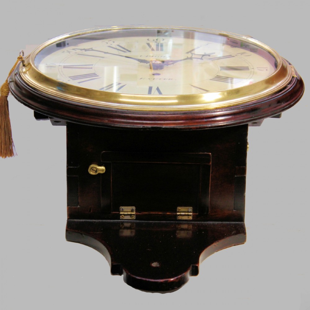 A late 18th-century Georgian mahogany wall clock featuring a circular cream painted dial with Roman numerals, a brass bezel, and a salt-box wooden case. View VII