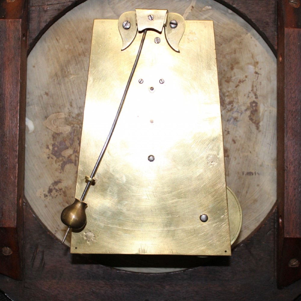A late 18th-century Georgian mahogany wall clock featuring a circular cream painted dial with Roman numerals, a brass bezel, and a salt-box wooden case. View XIII