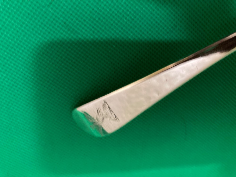 An antique silver punch ladle featuring a deeply fluted shell-shaped bowl and a curved handle with an engraved crest at the terminal. View IV