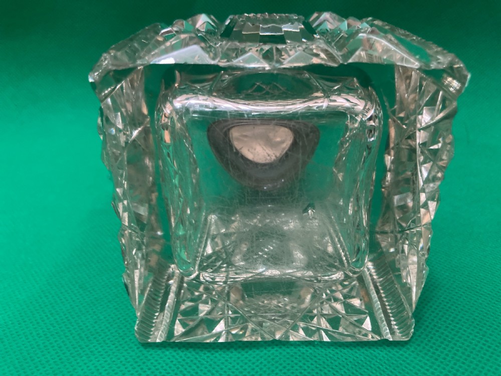 A square clear cut glass inkwell with a diamond facet pattern and a polished silver hinged domed cap. View V