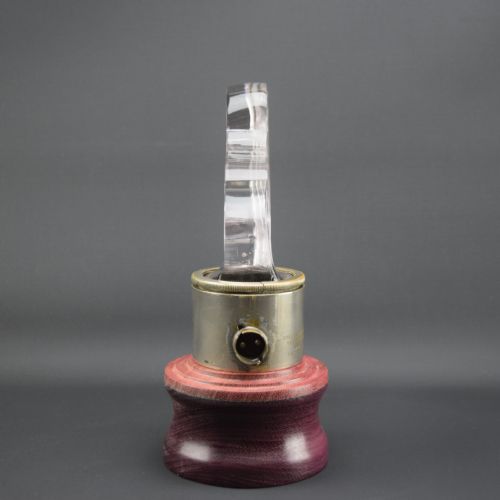 fig 1. An Art Deco clear moulded glass car mascot depicting five galloping horses in profile, mounted on a cylindrical metal collar and turned wood base.