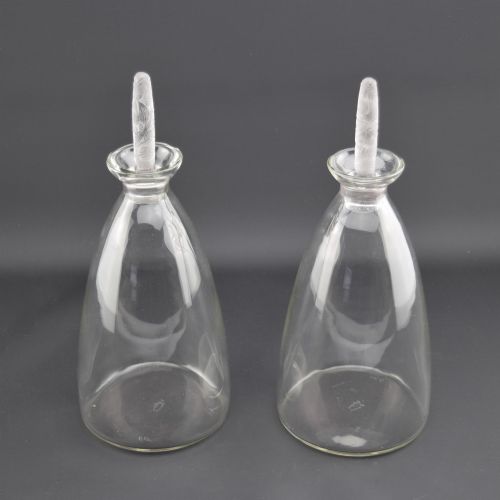 fig 1. A pair of clear glass Art Deco conical decanters featuring elongated frosted glass stoppers with delicate leaf motifs.