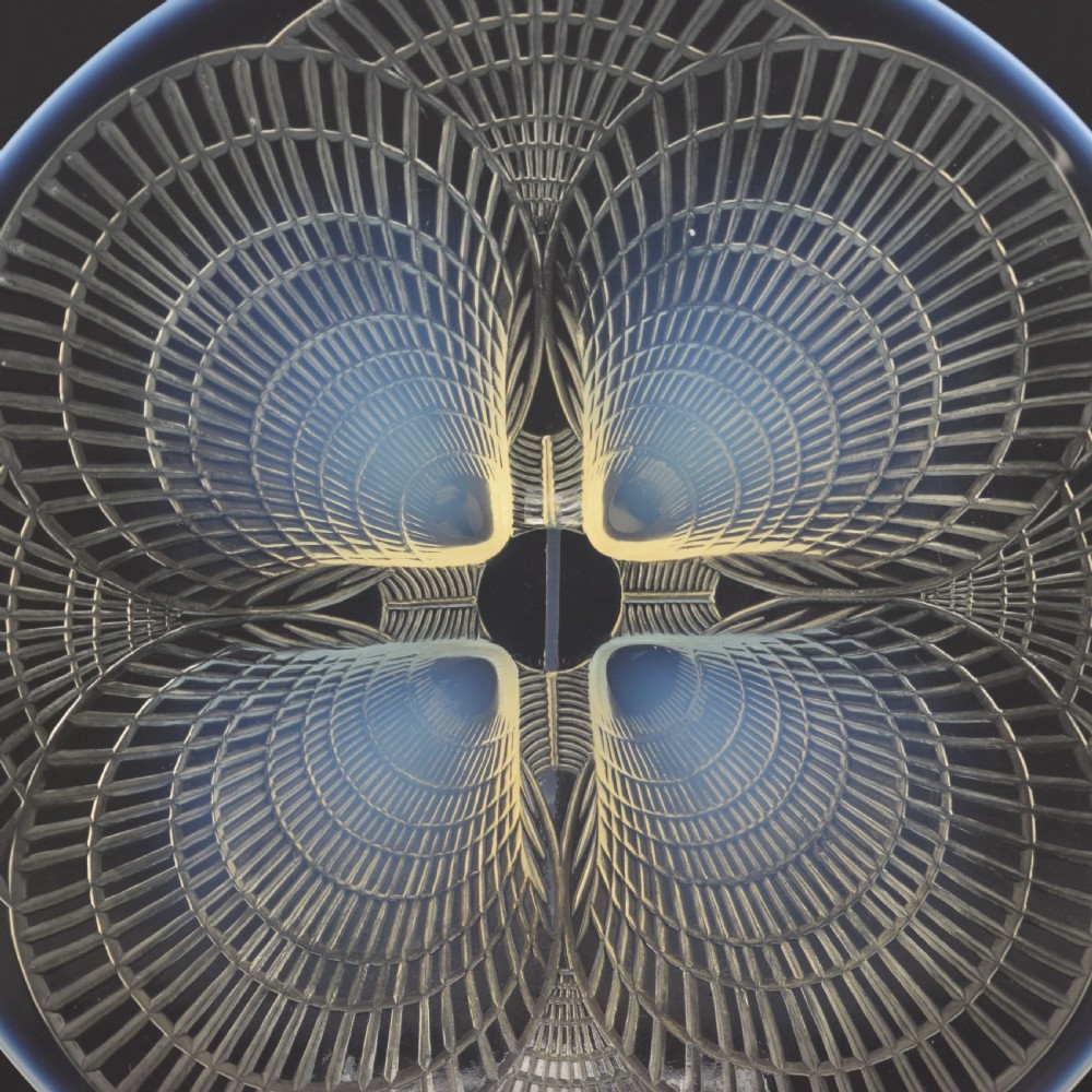 A circular Art Deco opalescent glass plate featuring a relief-moulded four-shell Coquilles design with milky blue tones. View III