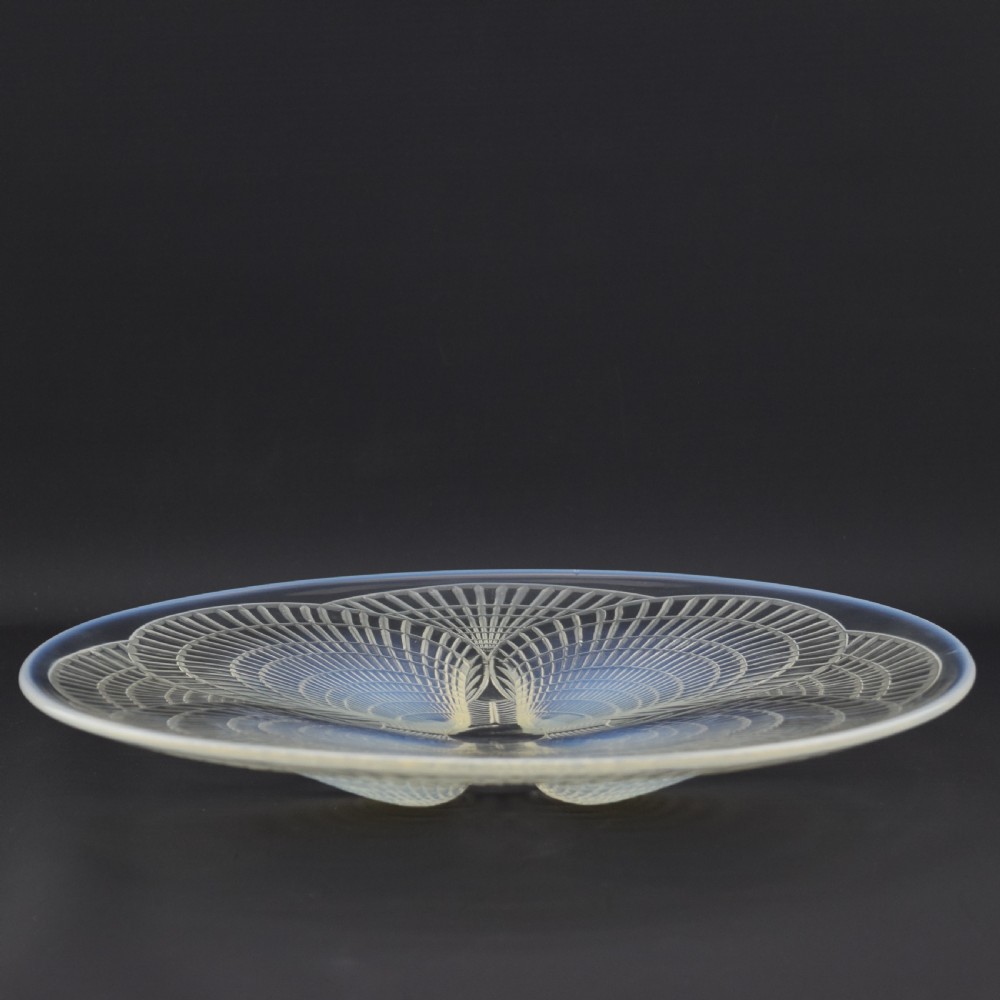 A circular Art Deco opalescent glass plate featuring a relief-moulded four-shell Coquilles design with milky blue tones. View VII