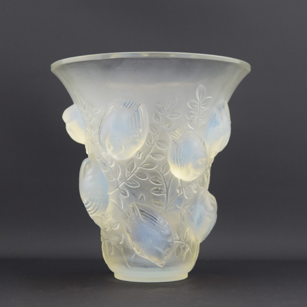 An Art Deco opalescent glass vase with a flared rim featuring moulded high-relief motifs of birds amongst leaves.