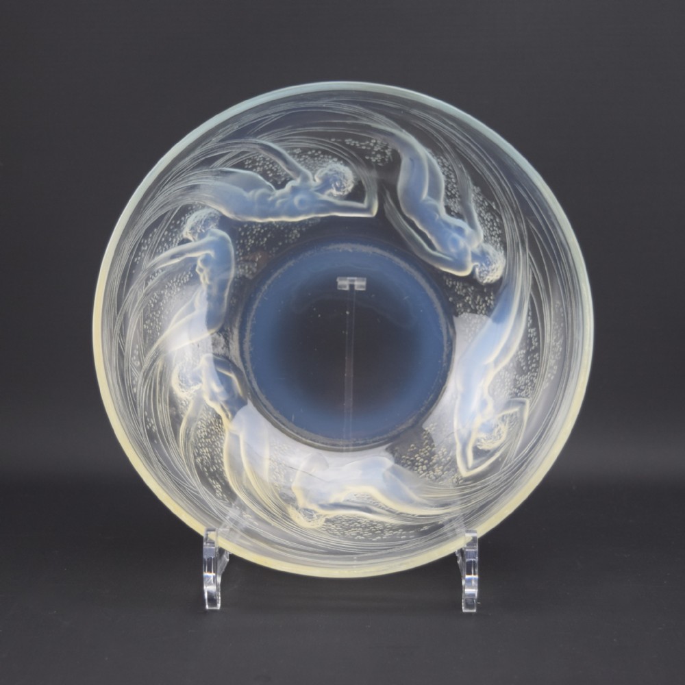 A circular opalescent glass bowl featuring relief-moulded figures of swimming water nymphs surrounded by stylized water bubbles.