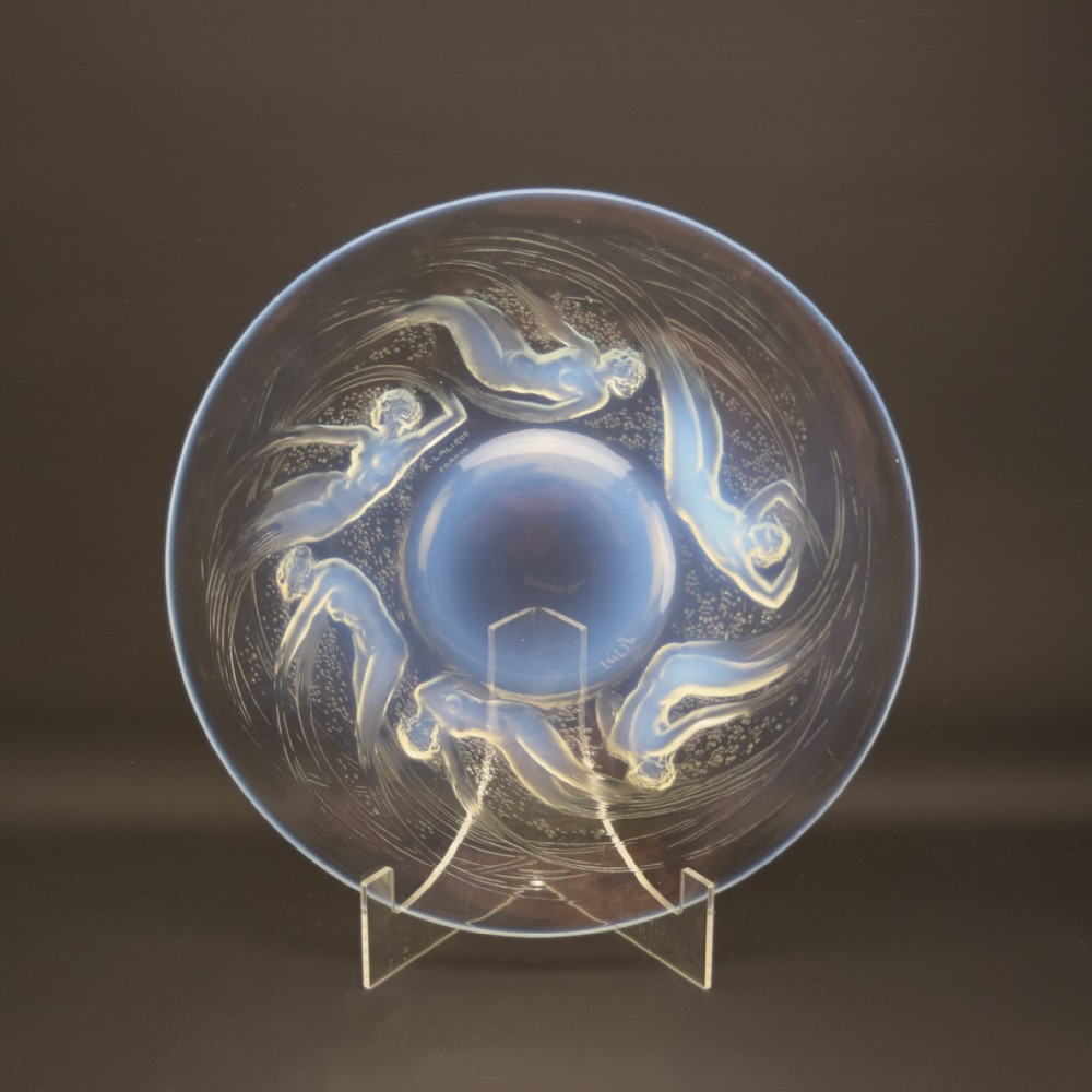 A circular Art Deco opalescent glass plate featuring six relief-moulded swimming female figures radiating around a central dome.