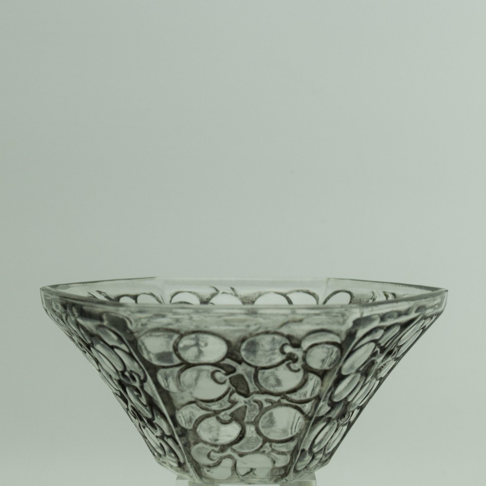A hexagonal Art Deco clear glass bowl featuring a moulded grape pattern with dark patinated recesses. View IV