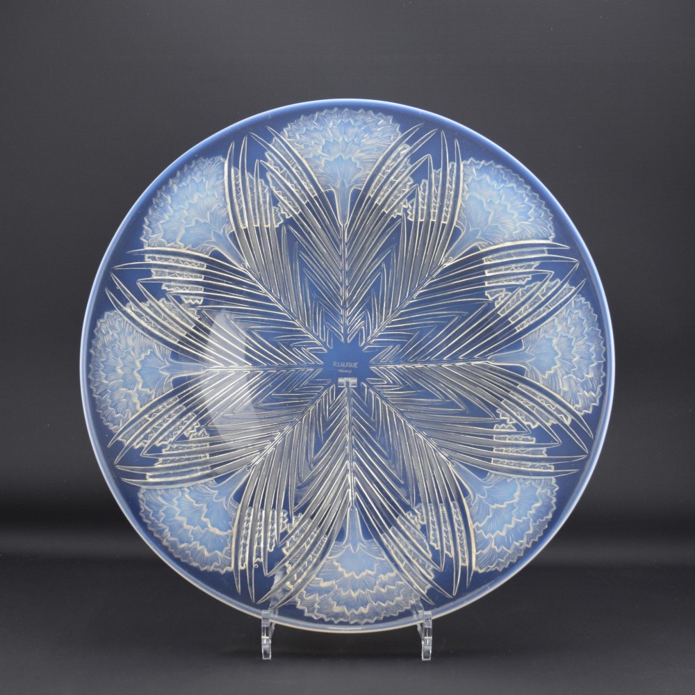 A circular Art Deco opalescent glass shallow bowl featuring a molded floral carnation design radiating from a central signature.